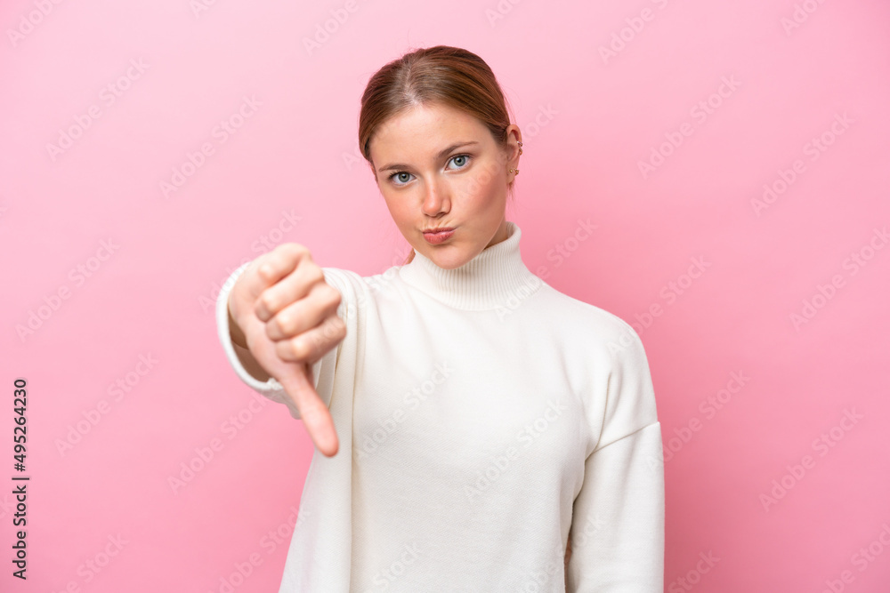 Young caucasian woman isolated on pink background showing thumb down with negative expression Young caucasian woman isolated on pink background showing thumb down with negative expression