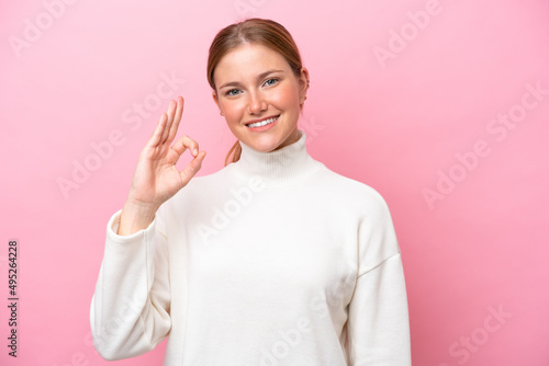 Young caucasian woman isolated on pink background showing ok sign with fingers