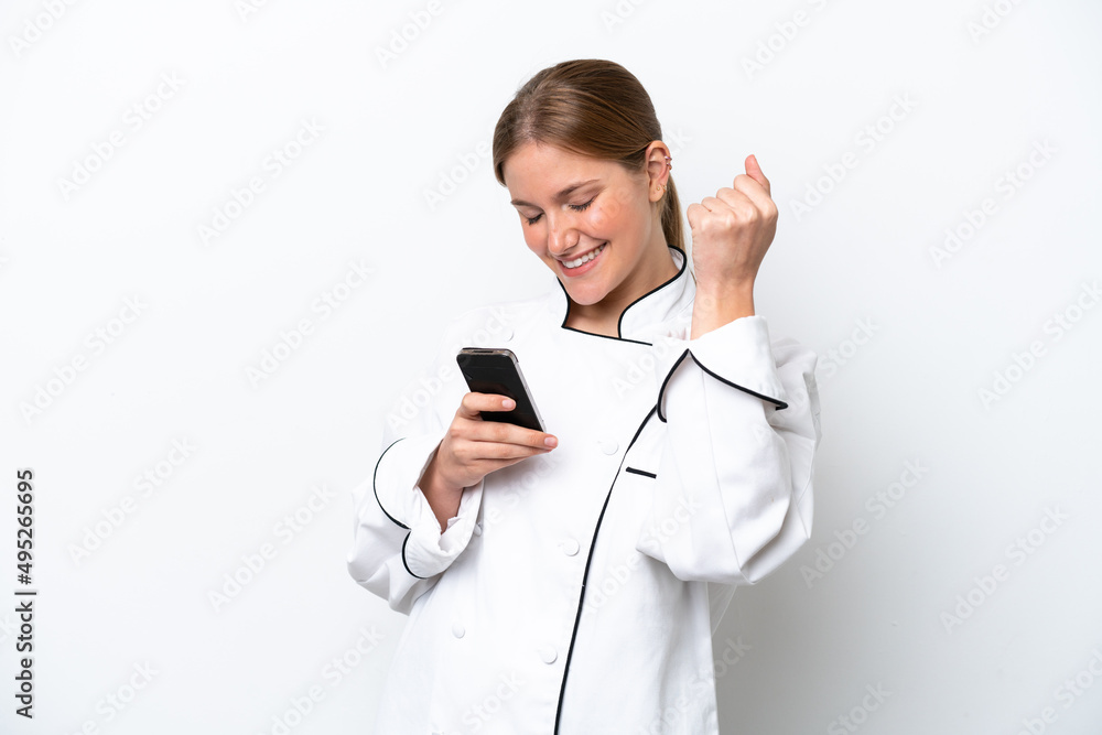Young chef woman isolated on white background with phone in victory position Young chef woman isolated on white background with phone in victory position