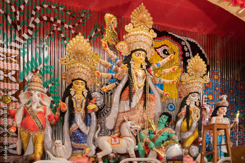 Goddess Durga idol at decorated Durga Puja pandal, shot at colored light, at Kolkata, West Bengal, India. Durga Puja is biggest religious festival of Hinduism and is now celebrated worldwide.