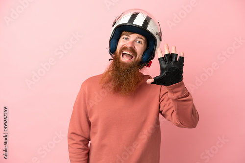 Young reddish caucasian man with a motorcycle helmet isolated on pink background counting five with fingers © luismolinero