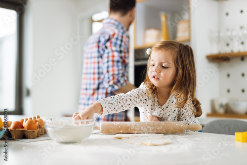 Cute little girl having fun while baking in the kitchen