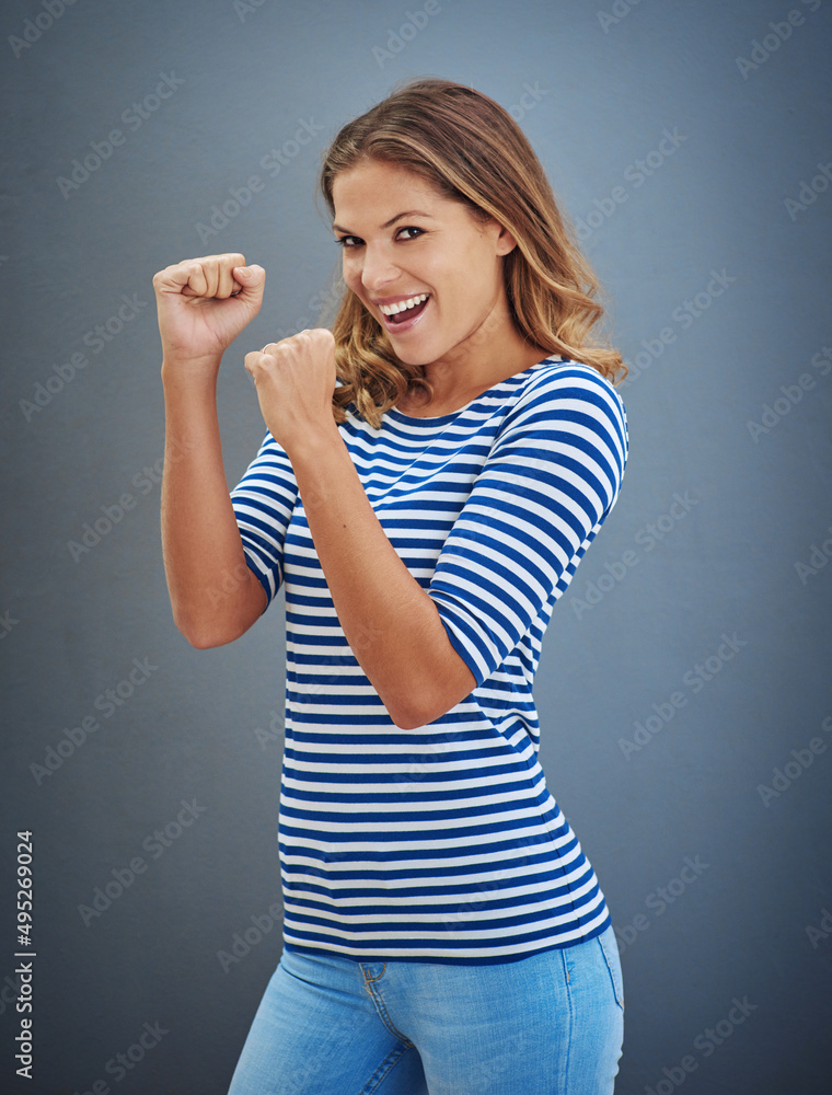 Never give up without a fight. Studio shot of a young woman putting up her fists against a gray background. Never give up without a fight. Studio shot of a young woman putting up her fists against a gray background.