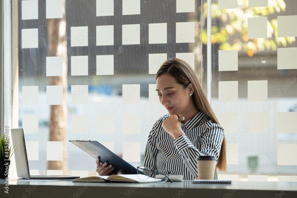 Businesswoman analysis turnover with graph chart report and use laptop computer for analysis data Businesswoman analysis turnover with graph chart report and use laptop computer for analysis data
