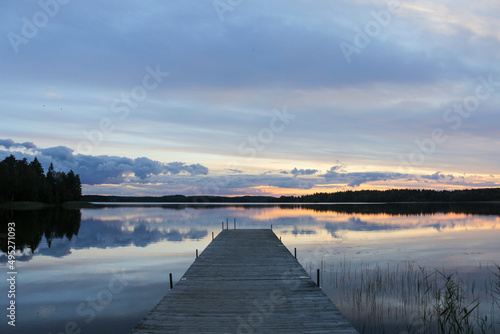 Quiet evening on a lake in Finland. Landscape with a sunset over a wooden pier