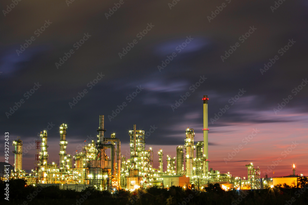Naklejka premium Oil refinery and plant and tower column of Petrochemistry industry in pipeline oil and gas industry with cloud slowing red sky