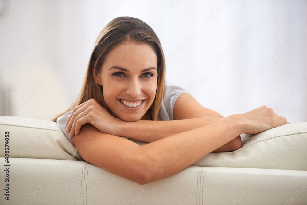 Enjoying sofa time. Portrait of a comfortable woman sitting in her living room. Enjoying sofa time. Portrait of a comfortable woman sitting in her living room.