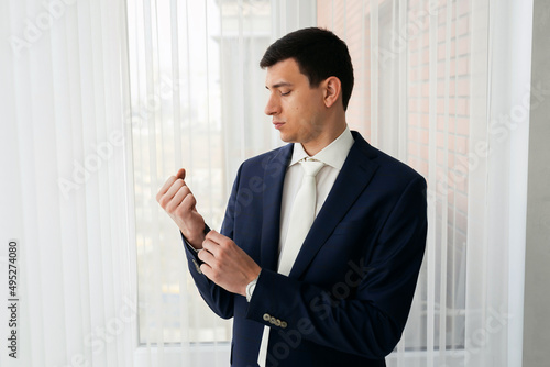 A respectable businessman in a hotel room, standing near the window. Groom's fees