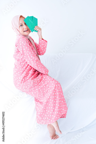 A picture of lady showing "duit raya" envelope on white background. Eid Al Fitr celebration concept.
