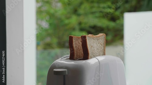 Two pieces of bread jump out of the toaster. Close-up shot.