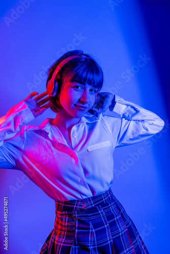  High Fashion model woman in colorful bright neon blue and purple lights posing in studio. Portrait of beautiful woman with trendy glowing make-up. Art design vivid style   © FATIR29