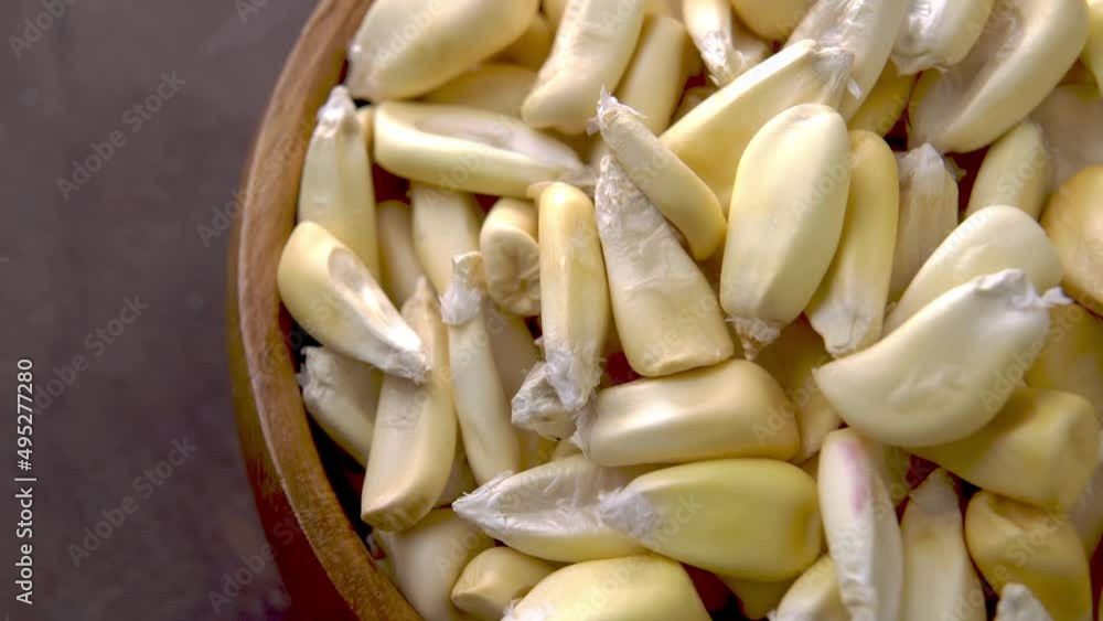 Cancha corn seeds on rustic wooden bowl. Dried maize. Macro. Rotation Cancha corn seeds on rustic wooden bowl. Dried maize. Macro. Rotation