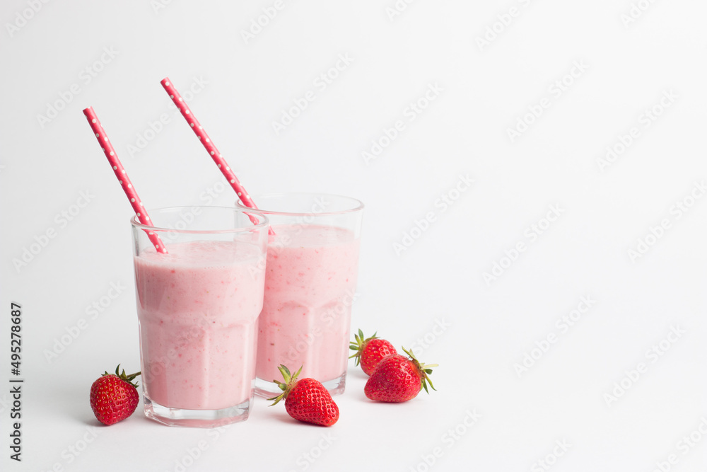 A glass of fresh strawberry smoothie on a white background. Summer drink shake, milkshake and refreshment organic concept. A glass of fresh strawberry smoothie on a white background. Summer drink shake, milkshake and refreshment organic concept.