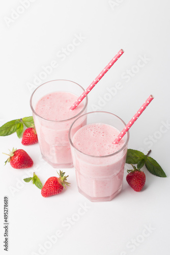 A glass of fresh strawberry smoothie on a white background. Summer drink shake, milkshake and refreshment organic concept.