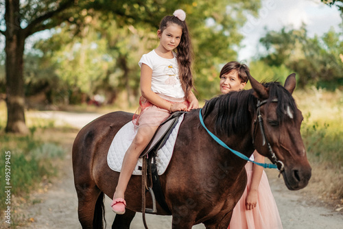Walk mother with daughter and horse in the summer in the forest. © sergo321