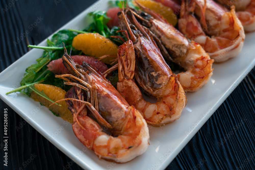 Grilled tiger prawns or shrimps with orange grapefruit and greens on a plate Grilled tiger prawns or shrimps with orange grapefruit and greens on a plate