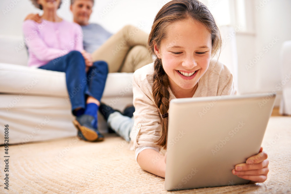 Staying entertained wherever she is. Shot of grandparents watching their granddaughter use a digital tablet. Staying entertained wherever she is. Shot of grandparents watching their granddaughter use a digital tablet.