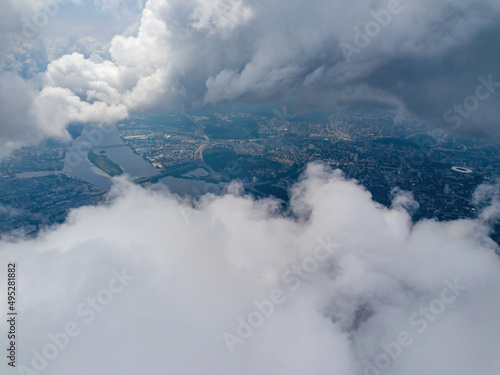 Kyiv city through high clouds. Cloudy day. Aerial drone view.