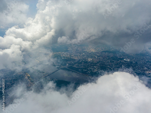 Kyiv city through high clouds. Cloudy day. Aerial drone view.
