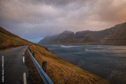 Faroe Islands  Kalsoy island  Husar village in sunset light durig twilight with pink sky and cliffs. November 2021