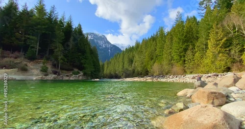 Establishing shot of majestic mountain river with mountain background in Vancouver, Canada, North America. Day time on April 2021. Still camera view. ProRes 422 HQ.