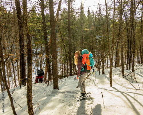 A young woman on snow shoes with a back pack off trail in the boreal forest. Shot outside Algonquin Park in the Ottawa Valley, Eastern Ontario, Canada photo