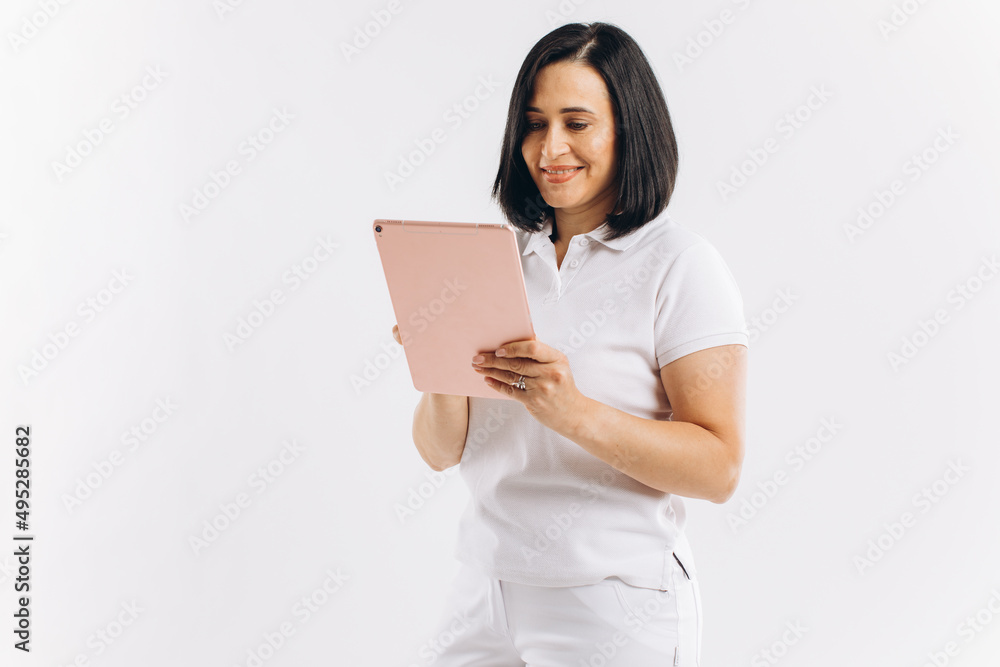 Woman in white uniform holding a tablet on a white background. Woman in white uniform holding a tablet on a white background.