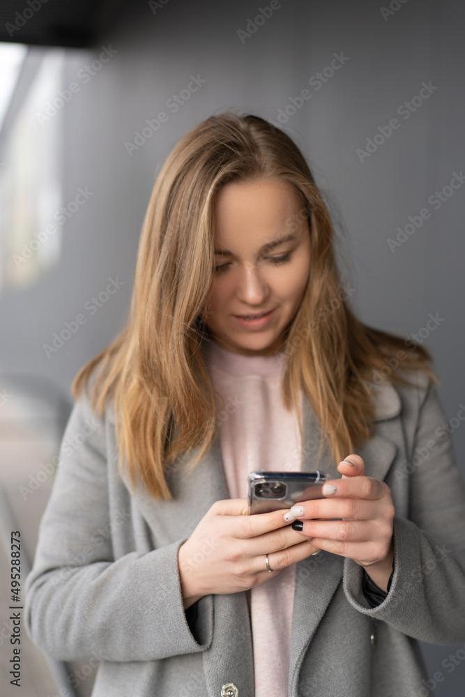 Woman working on her phone outdoors. Cold autumn weather Woman working on her phone outdoors. Cold autumn weather