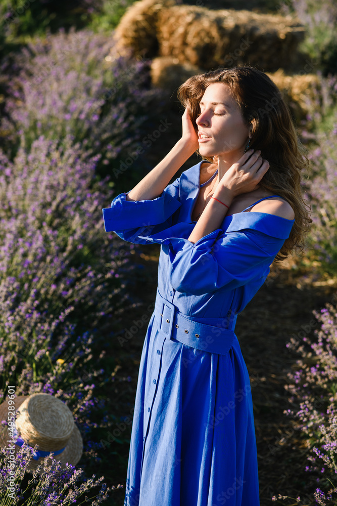 Attractive sensual young woman in retro blue dress posing in a lavender field. View from above. Attractive sensual young woman in retro blue dress posing in a lavender field. View from above.