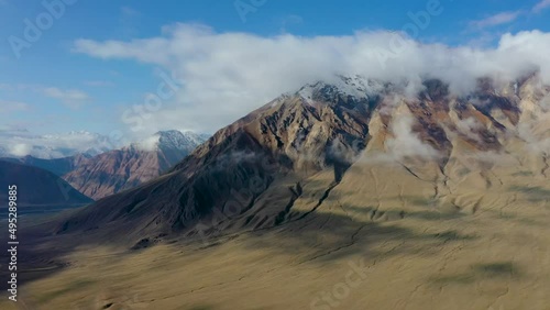 Aerial over arid mountains near Wakhan corridor.Mountain highway silk road trip adventure in desert region.4k drone flight establisher video