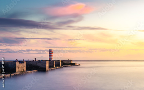 Sunset at the beach with a lighthouse