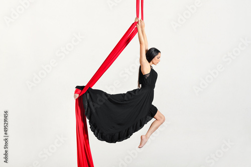Flexible woman performing tricks on aerial silks
