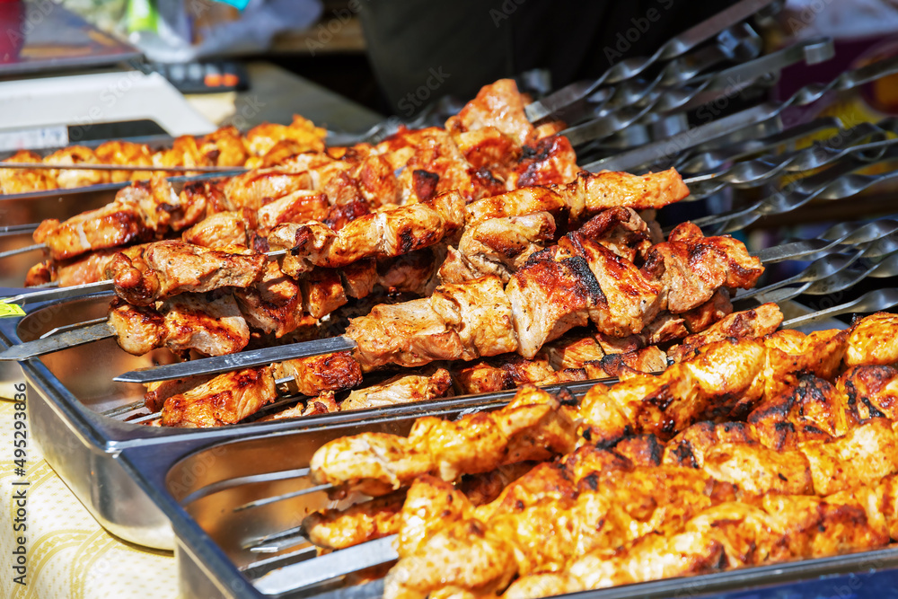 large number of juicy pork kebabs on skewers outdoors, closeup