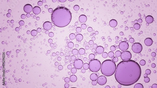 Macro shot of violet different sized transparent oil drops and bubbles floating clear fluid on pale purple background | Abstract skin care product ingredients concept