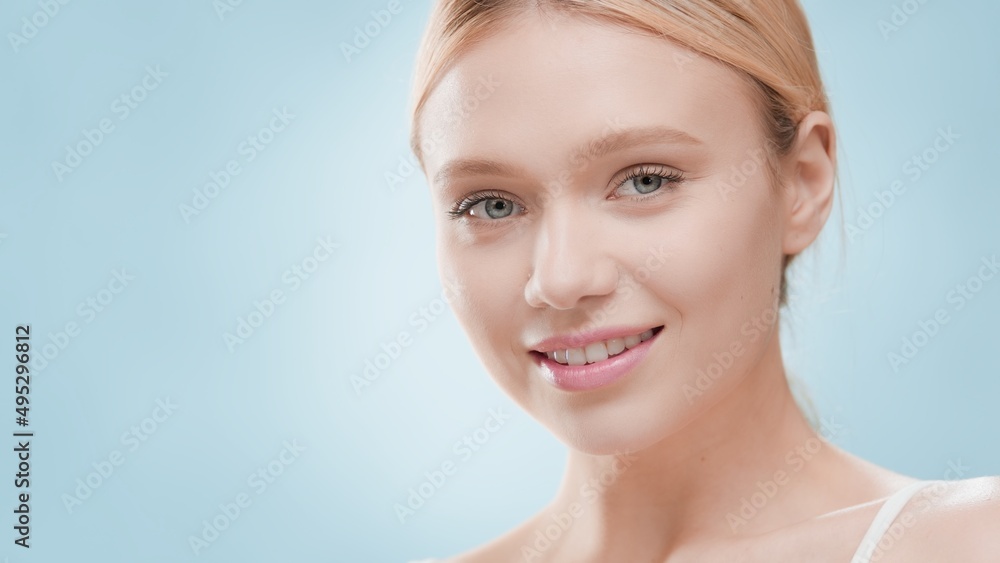 Big close-up beauty portrait of young blond Caucasian woman on blue background | Skin and body care commercial concept Big close-up beauty portrait of young blond Caucasian woman on blue background | Skin and body care commercial concept