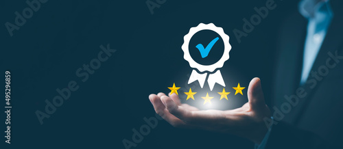 Quality assurance of business services and five star, Businessman hand shows the sign of the top service Quality assurance, Guarantee, Standards, ISO certification and standardization concept. photo