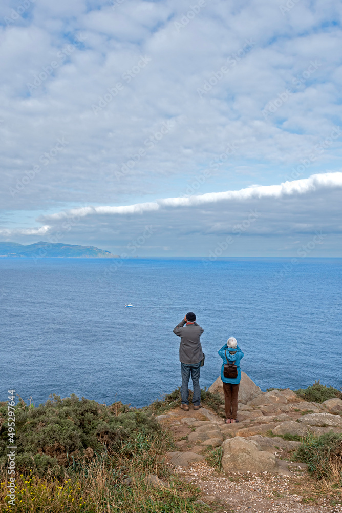 Senior couple looking through binoculars at Punta Estaca de Bares in Galicia, Spain