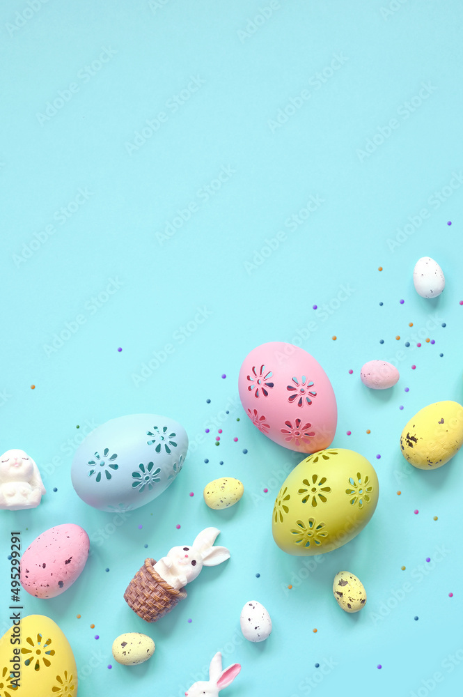 Easter composition. Easter eggs and easter bunny on pastel blue background. Minimal concept of Easter. Flat lay, top view, copy space.