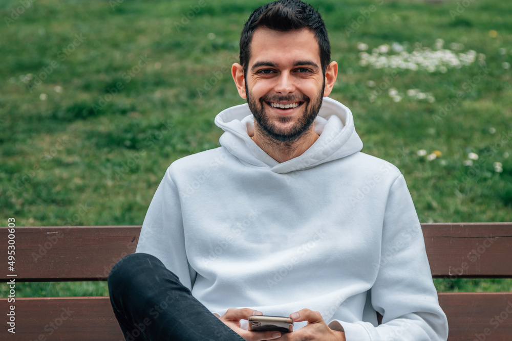 young man on bench with mobile phone