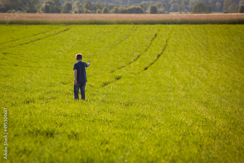 Chłopiec na polu - patrzeć w przyszłość - droga naprzód - perspektywa przyszłości - na wsi - pole - wzrost - zboże - natura - młode pokolenie photo