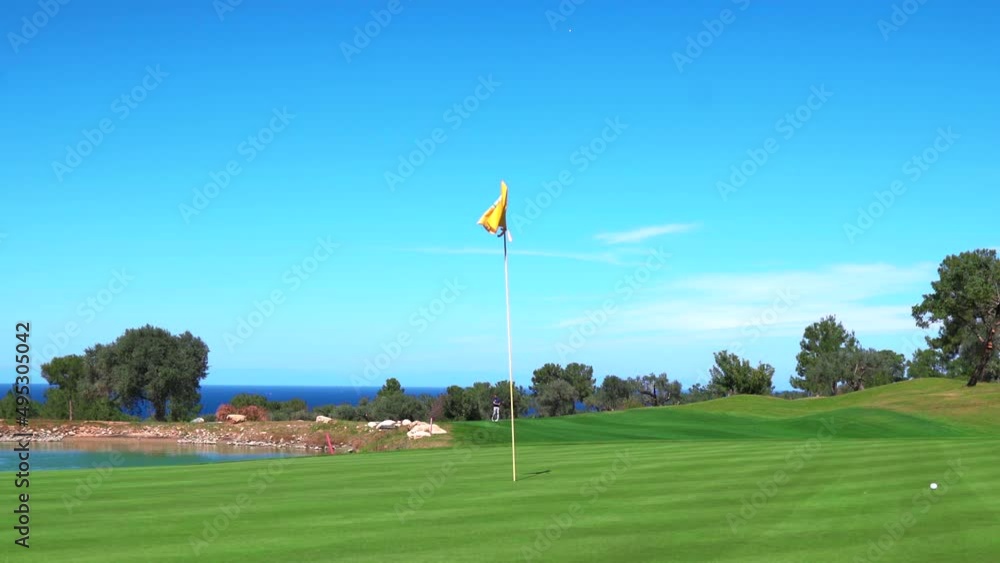 Man playing golf on beautiful course, putting on the green into the hole Man playing golf on beautiful course, putting on the green into the hole