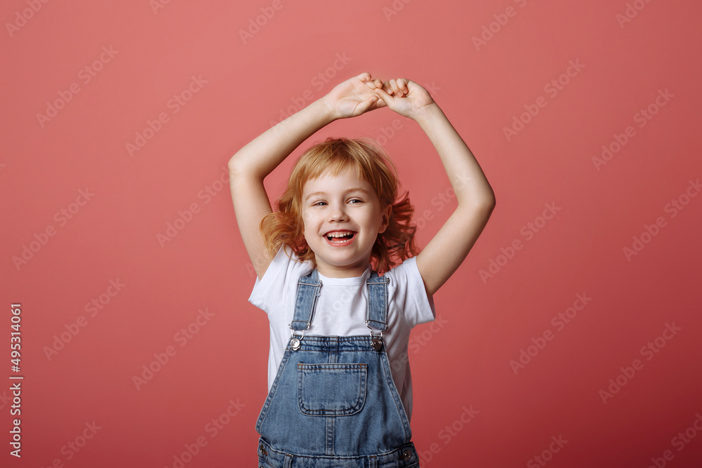 Cheerful little girl jumping on a pink background. Cheerful little girl jumping on a pink background.