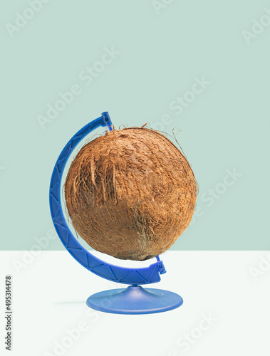 Minimal raw plant based concept. One organic coconut set in a rotating blue stand. Pastel blue and beige background.