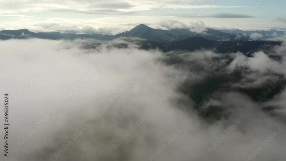 Mountains rise above the clouds of thick fog. Footage from a bird's eye view. Mountains rise above the clouds of thick fog. Footage from a bird's eye view.