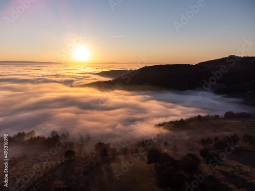 Drone view of Umbria valley Italy above a sea of fog at sunset