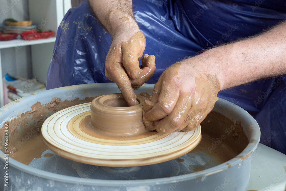 senior pottery man hands sculping from clay on pottery wheel pot in workshop. Concept of ceramic hobby art