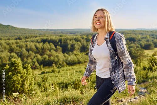 Portrait of happy female hiker wandering with backpack during summer © baranq