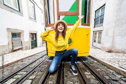 Woman tourist with famous yellow funicular tram of Lisbon, Portugal - Tourist attraction - Europe destinations lifestyle concept photo