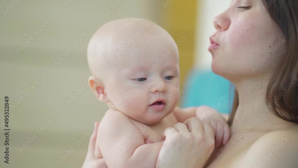 a beautiful and gentle mother kisses a baby. happy childhood and motherhood. a beautiful and gentle mother kisses a baby. happy childhood and motherhood.