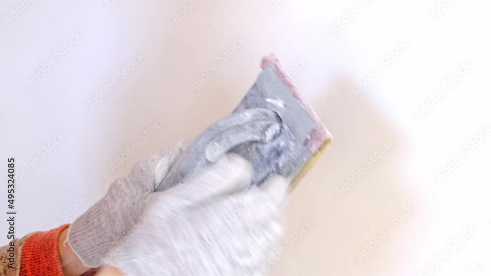 Sanding of walls with sandpaper after treatment with dry building mixes